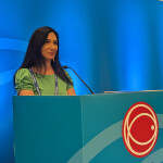 Macro-economist, geopolitical finance expert, and best-selling author Nomi Prins at a podium at the 2025 Seafood Expo North America