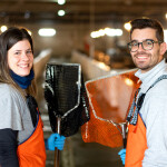 Two employees of Stolt Sea Farm holding small fish nets.