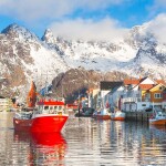 A fishing boat pulls out of a harbor in Norway
