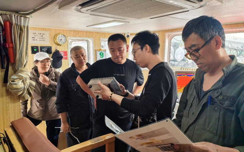Researchers explaining the process to the squid vessel's crew