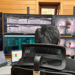 A Mowi employee monitoring a salmon farm at a bank of computer monitors