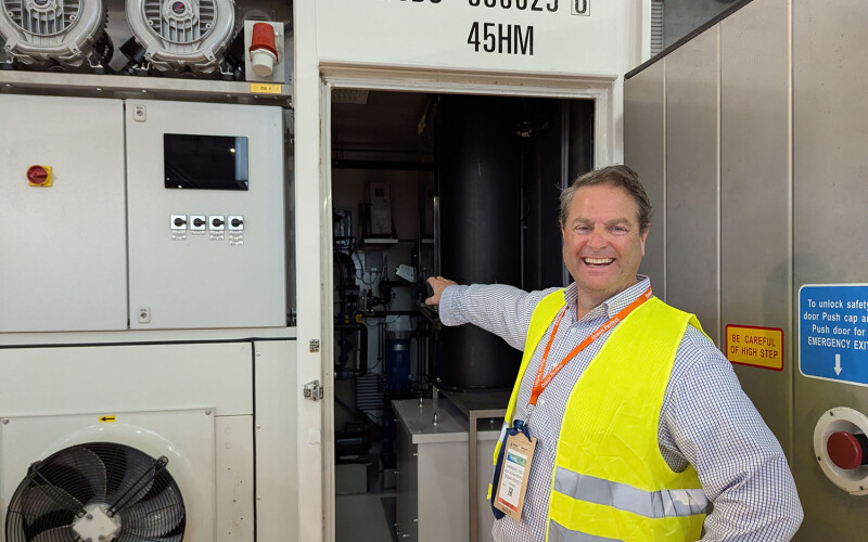 Ocean Perfect CEO Andrew Lively pointing at the company's shipping container system