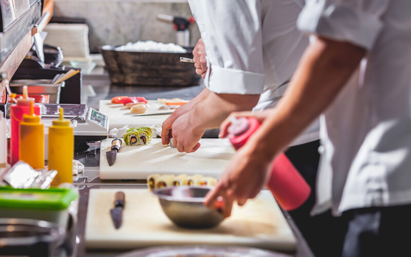 A close-up of restaurant chefs preparing sushi