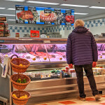 A woman standing at a seafood counter in a grocery store