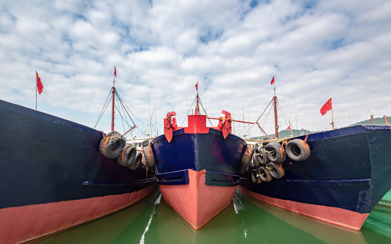Three Chinese fishing boats moored together at a port