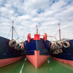 Three Chinese fishing boats moored together at a port