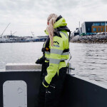 A SalMar employee on a boat facing away from the camera on a boat