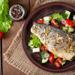 Baked seabass on top of a bed of vegetables