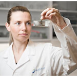 A scientist holding up a piece of equipment
