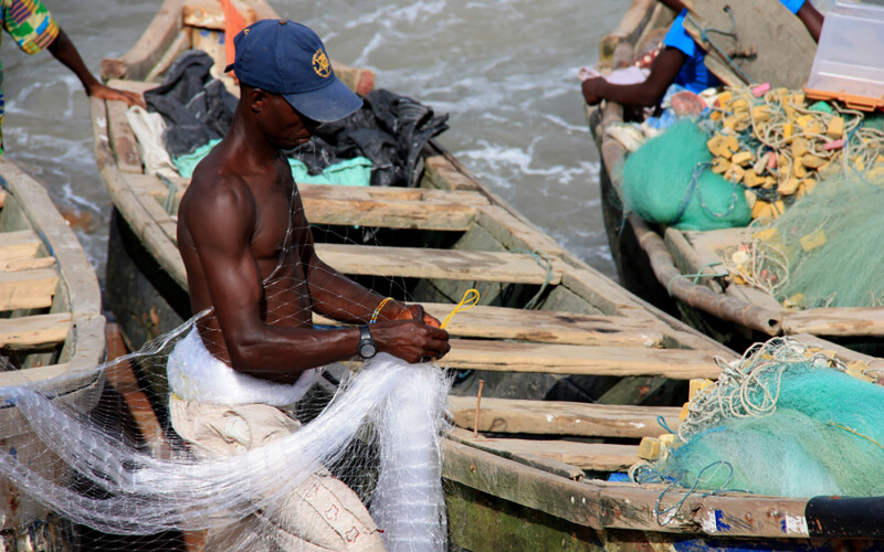 A Ghanaian fisherman untangling a net