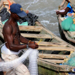 A Ghanaian fisherman untangling a net