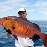 A man holding a red snapper