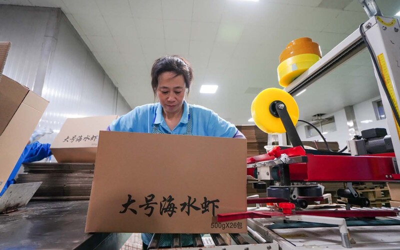 A woman packing a box full of prawns