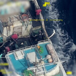 A fisher in the North Pacific throwing a shark off of a fishing vessel