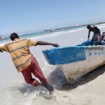 Fishermen pulling their boat toward the water off of Mogadishu, Somalia