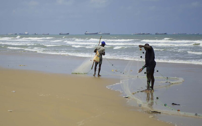 Gabon fishermen hauling in nets on the shore
