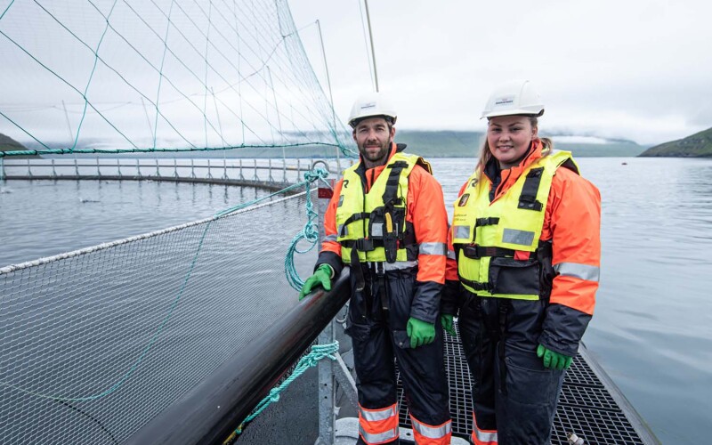 Bakkafrost employees standing on a net pen