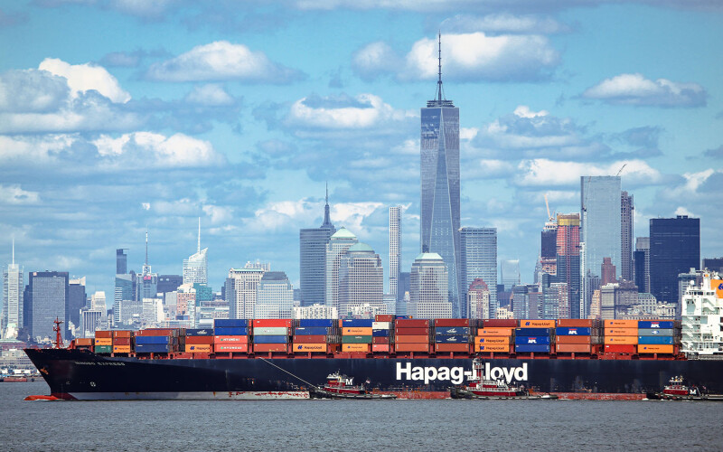 A shipping vessel with the skyline of New York City in the background
