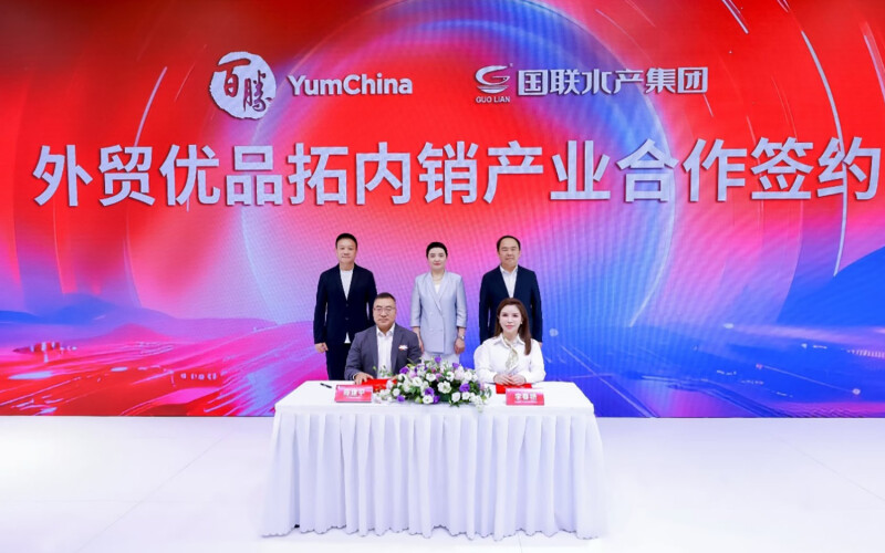 Yum China and Guolian reps signing a supply partnership agreement