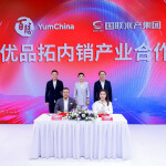 Yum China and Guolian reps signing a supply partnership agreement