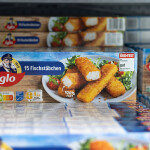 A grocery store refrigerated case containing iglo brand fish sticks