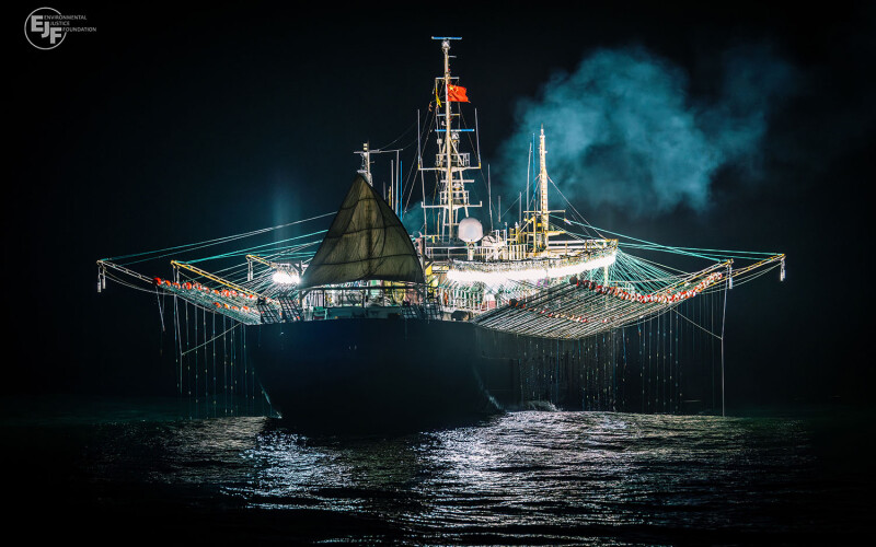 A squid jigger fishing at night with lights on