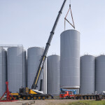 A crane installing a large storage tank