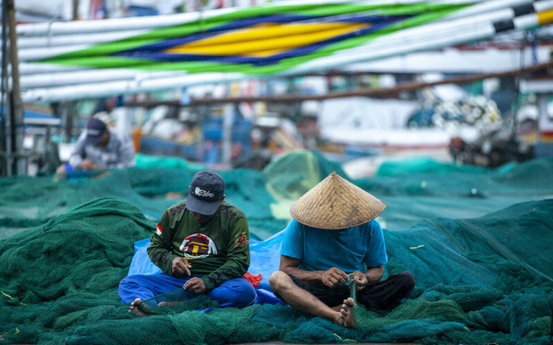 Indonesian fishers untangling netting