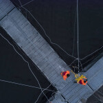 An aerial shot of two Australis employees working on one of the firm's net pens