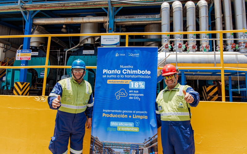 Workers posing in front of a promotional poster for the new project