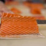 A chef slicing a piece of salmon
