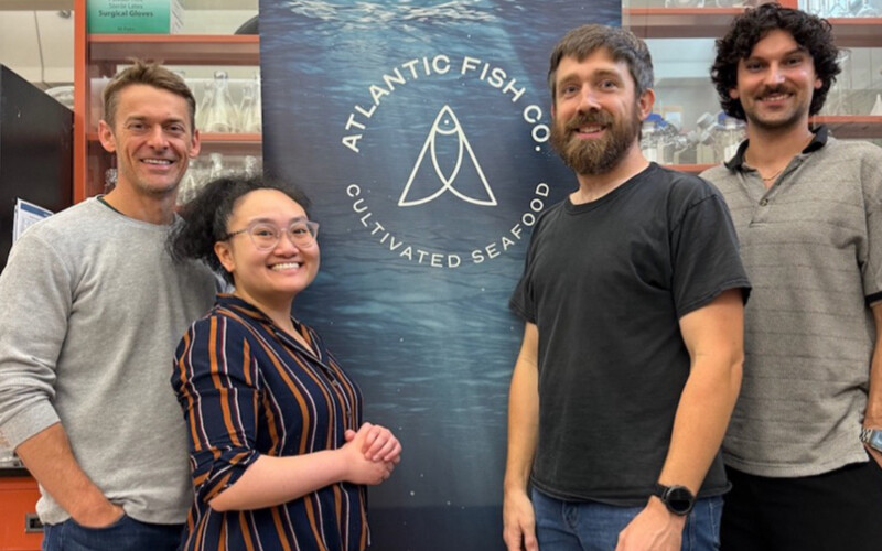 Staff at Atlantic Fish Co posing before a banner