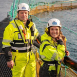 Lerøy Seafood Group employees standing on a net pen