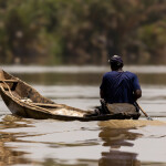 A Gambian fisherman rowing his canoe