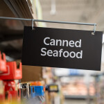 A canned seafood sign in a grocery store