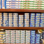 A set of shelves with tuna cans