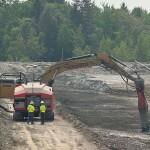 Workers preparing the former Great Northern Paper Co. paper mill's settling lagoon for constructino