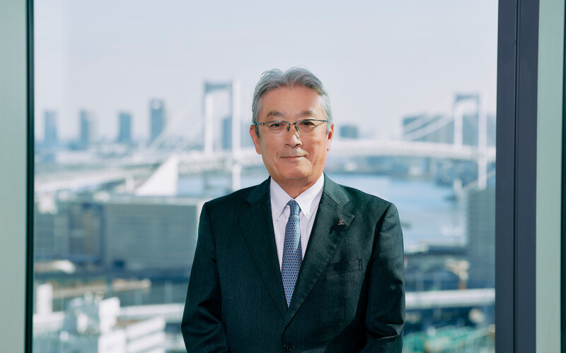 Umios CEO Masaru Ikemi with the Tokyo skyline behind him
