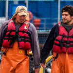 Salmones Camanchaca employees standing on a net pen