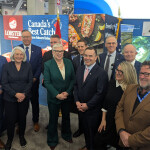 Canadian fisheries ministers pose in a booth at Seafood Expo North America