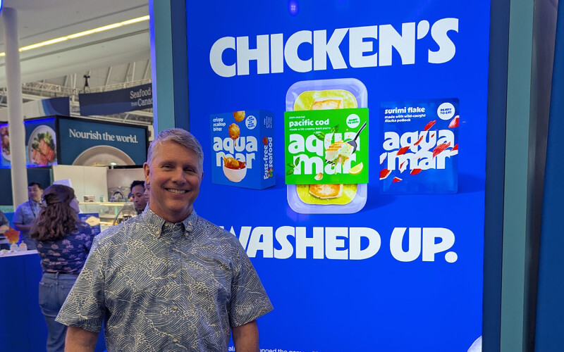Aquamar CEO Daryl Gormley in front of a sign at Seafood Expo North America