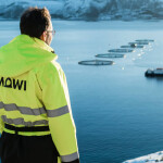A Mowi employee staring out at net pens