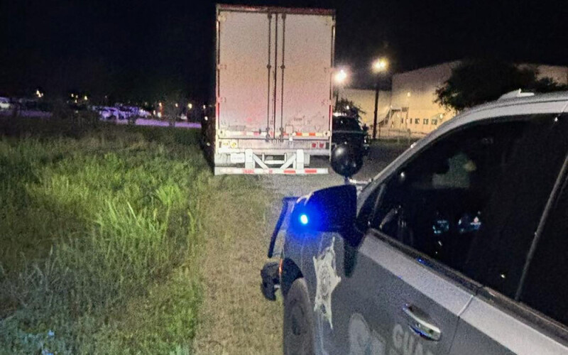 A truck being pulled over by a police vehicle