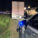 A truck being pulled over by a police vehicle
