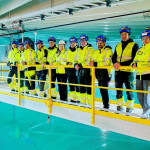 Salmon Evolution employees on the edge of a tank at the firm's Indre Harøy facility