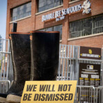 A pair of boots with a sign saying "we will not be dismissed" in front of Bumble Bee Seafoods headquarters