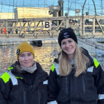 Two people standing at a salmon farm