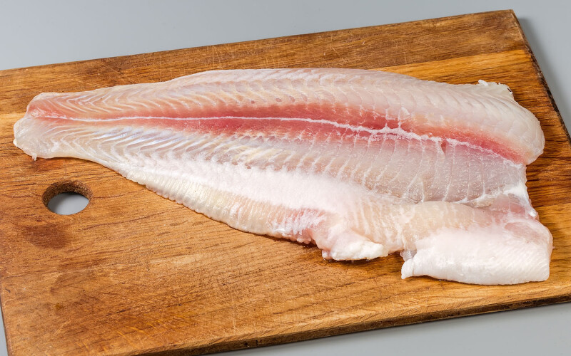 A pangasius fillet on a cutting board