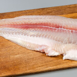 A pangasius fillet on a cutting board