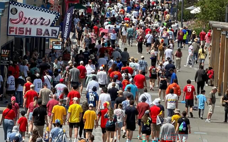 A crowd of soccer fans in front of an Ivar's restaurant